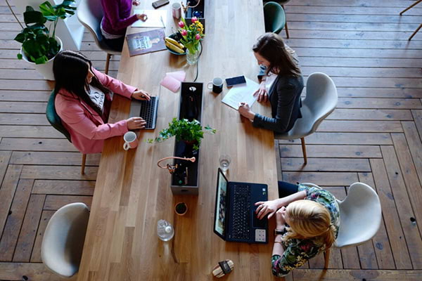 A group of Fuse Digital employees working on their laptops at a long work desk