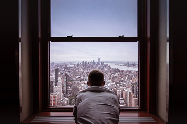 A digital agency employee sitting by a window looking at the city views
